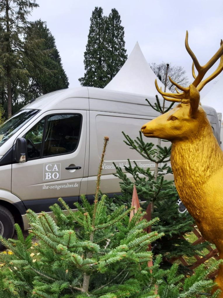 Goldener Hirsch inmitten von Weihnachtsbäumen auf Burg Wissem