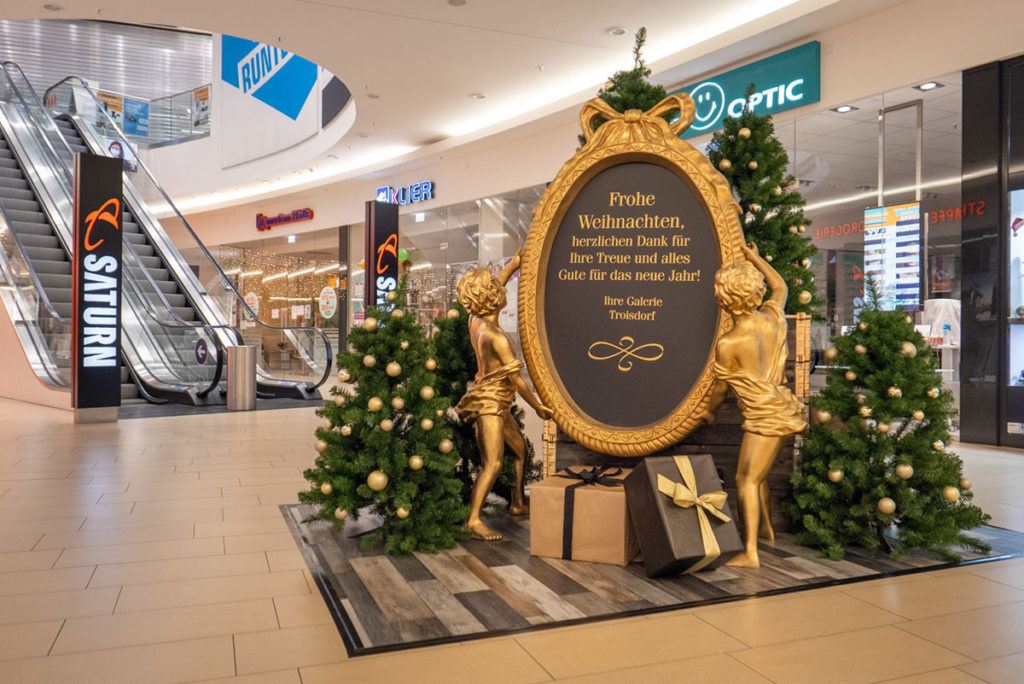 Goldene Engel halten ein Schild mit einem Weihnachtsgruß.